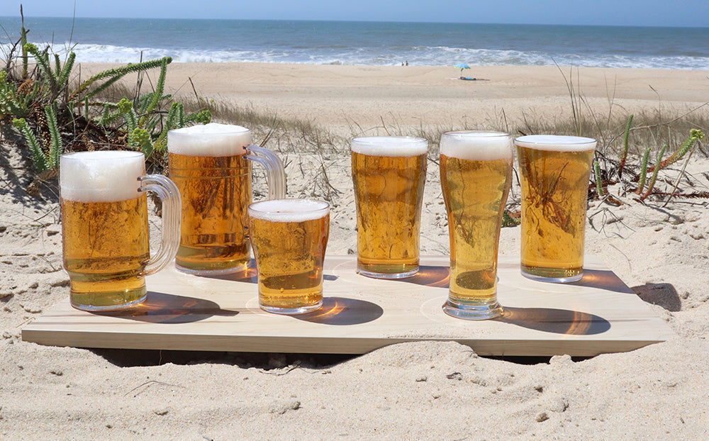 Copos de cerveja MPDrink com cerveja e espuma, fundo praia